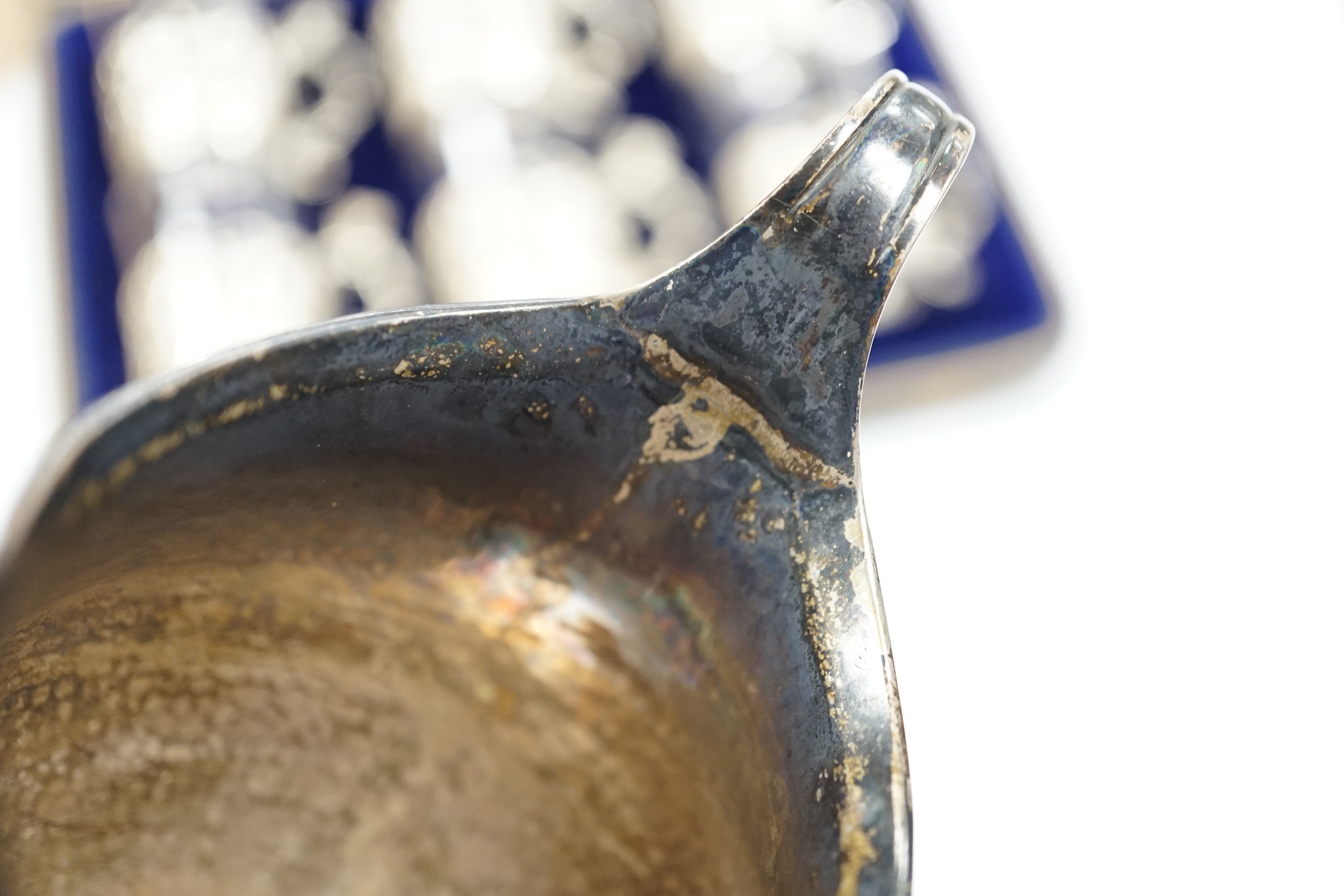 A George III engraved silver helmet shaped cream jug, Francis Purton?, London, circa 1790, height 10.6cm (a.f.), together with a cased set of six George V silver coffee can holders, with glass inserts, Marples & Co, Birm